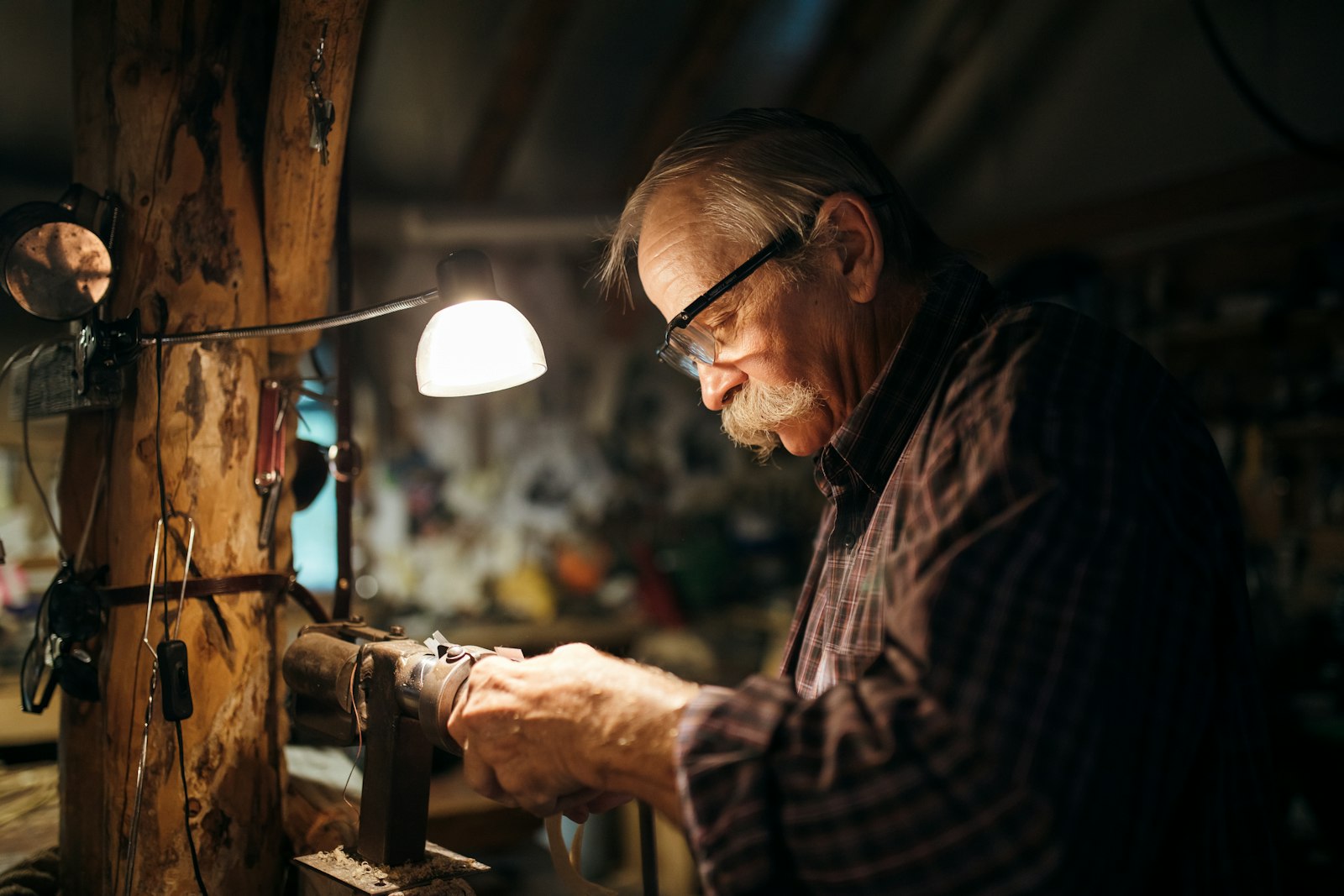 An older machinist teaching a younger worker at a machine